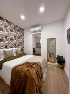 1 dormitorio con 1 cama grande y pared de flores en Crysoyle Apartment Barcelona Next to Camp Nou, en Barcelona
