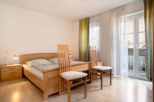 una camera con letto, scrivania e sedie di Ferienwohnungen Shamal a Reutin