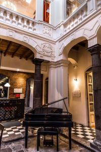 un pianoforte in una stanza con pavimento a scacchiera di Carlota Sustainable Design Hotel a Quito