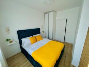 a bedroom with a bed with a yellow blanket at Apartament Vipii’s Residence in Arad