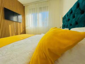 a bedroom with a large bed with a yellow blanket at Apartament Vipii’s Residence in Arad