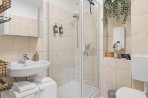 a bathroom with a shower and a sink and a toilet at PRIME - City Apartment für 6 - Neu & Modern in Munich