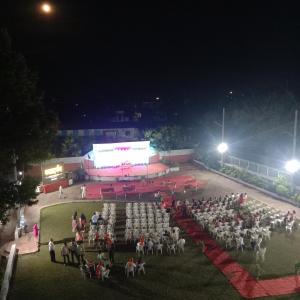 a group of people standing in front of a stage at night at HOTEL PRITAM PARK in Jālgaon