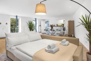 a living room with a couch with towels on a table at PRIME - City Apartment für 6 - Neu & Modern in Munich