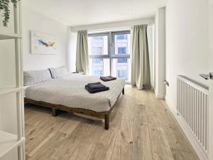 a bedroom with a bed and a large window at Beautiful 2 bedroom flat in Battersea in London