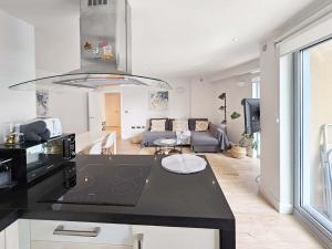 a kitchen and living room with a black counter top at Beautiful 2 bedroom flat in Battersea in London +15 photos