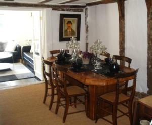 a dining room table and chairs in a living room at White Sheep Cottage in Peasenhall