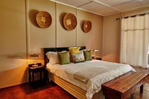 a bedroom with a bed and two plates on the wall at Cheetah Ridge Lodge in Nambiti Game Reserve +79 photos