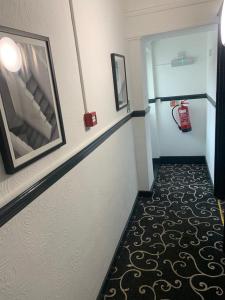 a corridor of a room with a fire extinguisheracistacistacistacist at Trinity Guest House in Hartlepool