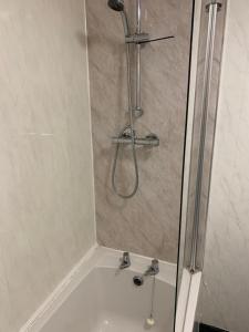a shower in a bathroom with a white tub at Trinity Guest House in Hartlepool