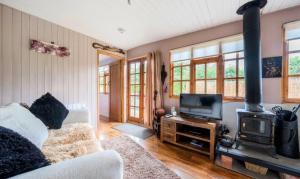 un soggiorno con divano e piano cottura di Clematis cabin a Hereford
