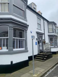 a white house with a street sign in front of it at Trinity Guest House in Hartlepool