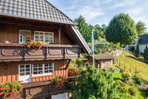 a wooden house with flower boxes on the windows at Dalblick in Oberharmersbach