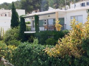 une maison blanche avec des arbres et des buissons dans l'établissement Villa in Albir, à L'Alfàs del Pi