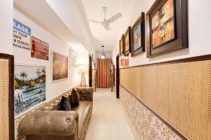 einen langen Flur mit Couch und Plakaten an der Wand in der Unterkunft House of Comfort Noida in Noida