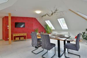 comedor con mesa y pared roja en Ferienwohnungen und Ferienzimmer Haus Waldblick Trusetal en Brotterode