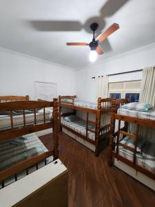 a room with bunk beds and a ceiling fan at Hostel Caminho da Praia in Arraial do Cabo