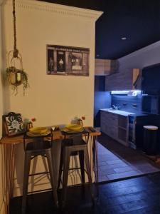 cocina con 2 taburetes y mesa en una habitación en The Penny Black Apartment With Indoor Hot Tub en Slamannan