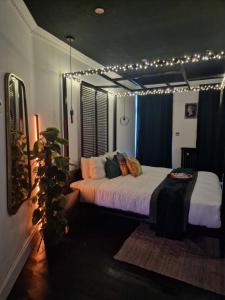 Un dormitorio con una cama con luces. en The Penny Black Apartment With Indoor Hot Tub en Slamannan