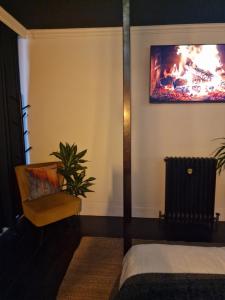 a bedroom with a bed and a fire in the wall at The Penny Black Apartment With Indoor Hot Tub in Slamannan