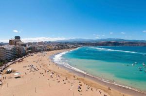 ein Strand mit vielen Menschen und dem Ozean in der Unterkunft Designer Studio Apartment 100m from the Beach in Las Palmas de Gran Canaria