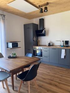 a kitchen with a wooden dining table and chairs at Ferienwohnung Hüttenflair in Amberg