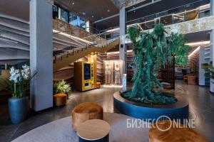 a lobby with a tree sculpture in the middle at Kravt Kazan Airport Hotel in Bol'shiye Kabany