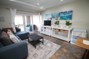 a living room with a blue couch and a tv at Mystique 17 in Shelly Beach
