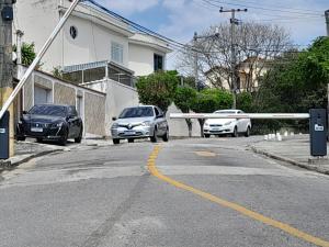 dos autos estacionados al lado de una calle en Apartamento Anchieta 7 Belo, en Río de Janeiro
