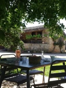 a table with two chairs and a stone wall at LA FERME JARLAN in Berganty