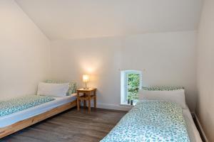 2 Betten in einem Zimmer mit Fenster in der Unterkunft Ferienwohnung Flut in Sandstedt