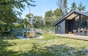 a black house with a backyard with a hot tub at Nice Home In Hadsund With Kitchen in Hadsund