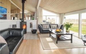 sala de estar con muebles de cuero y chimenea en Awesome Home In Hjrring With Indoor Swimming Pool, en Lønstrup