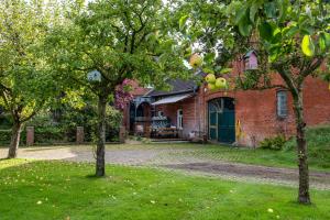 ein Backsteinhaus mit zwei Bäumen im Hof in der Unterkunft Ferienwohnung Flut in Sandstedt