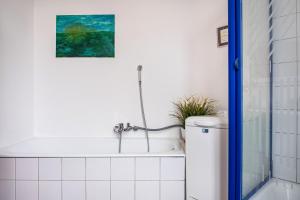 a bathroom with a bath tub and a painting on the wall at Ferienwohnung Ebbe am Weserstrand in Sandstedt +16 photos