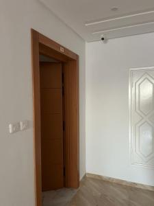 Habitación vacía con armario y puerta en Residence ElFaracha, en Sousse