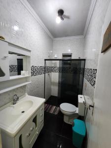 uma casa de banho com um lavatório, um WC e um chuveiro em Hostel Caminho da Praia em Arraial do Cabo