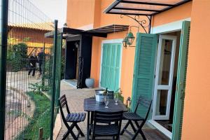 een patio met een tafel en stoelen en een hek bij Apto Roma na Vila Paraíso: um cantinho feliz in Maringá