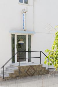 a white building with stairs in front of a door at Edgewater Studios in Kissamos