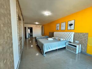 una camera da letto con un letto e una TV di Casa Grande Angra de Ipioca Hibiscus a Paripueira Altre 38 foto