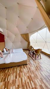 a bedroom with two beds and a desk in a tent at Yellow Star Camp Wadi Rum in Wadi Rum