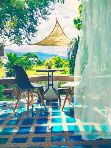 a table and chairs on a patio with a view at ม่วนโฮม muan home café&stay in Ban Don