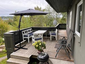 porche con mesa, sillas y sombrilla en Vestre Haugen House Sentralt OSLO Gratis privat parkering, en Høybråten