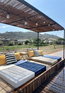 un groupe de lits assis sous une pergola dans l'établissement Viva! Farmhouse, à Monsaraz