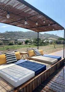 a group of beds sitting under a pergola at Viva! Farmhouse in Monsaraz