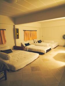 a bedroom with three beds in a room at ม่วนโฮม muan home café&stay in Ban Don
