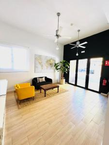 a living room with a yellow chair and a couch at Suites Puente de Hierro in Benicàssim