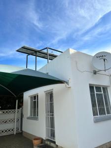 ein weißes Gebäude mit grünem Regenschirm drauf in der Unterkunft Mels Place in Bloemfontein