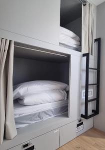 Letto a castello bianco con cuscini bianchi di Aloha Surf Hostel a Somo