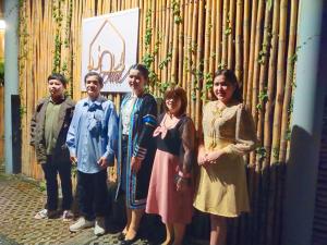 a group of people standing in front of a bamboo wall at ม่วนโฮม muan home café&stay in Ban Don